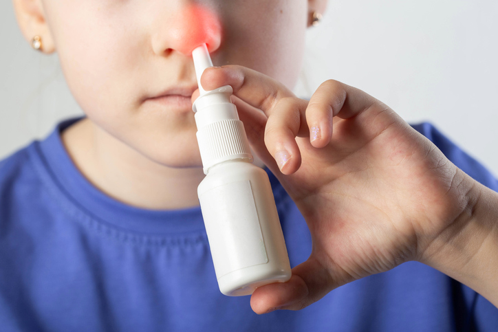 woman using a nasal spray for her sinuses