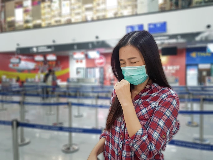 female traveler wearing a face mask at the airport