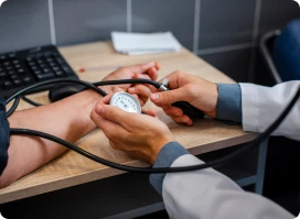Close-up of a doctor taking a patient's blood pressure with a sphygmomanometer.