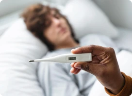 Close-up of a hand holding a digital thermometer showing a reading.