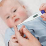 A caregiver checks a baby's temperature using an electronic thermometer, ensuring the child's health and Fever