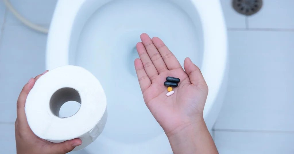 Pills in hand highlighting antibiotics causing diarrhea.