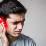 Man holding his ear in pain with a red highlight indicating earache.